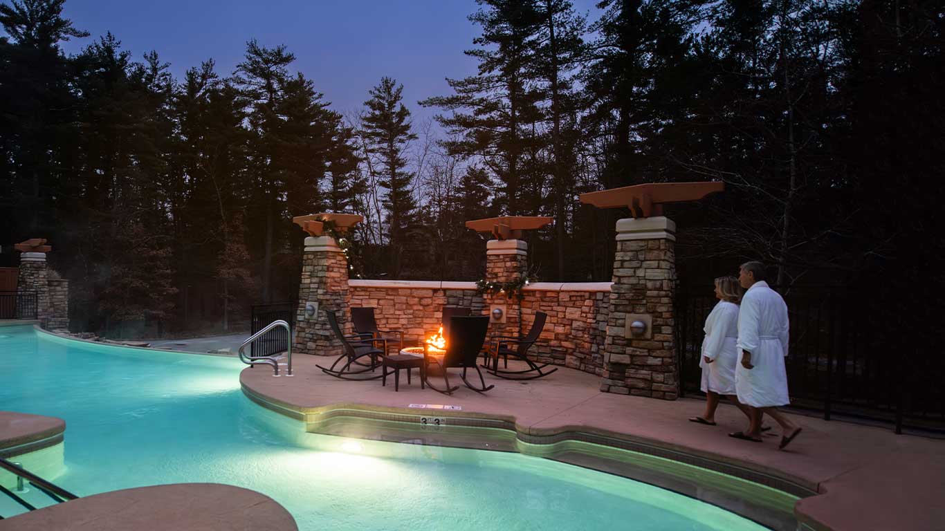 Couple walking along heated outdoor pool - winter